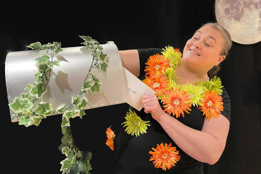 Aurore la comédienne conteuse joue une scène avec sa boite aux lettres mystérieuse et son courrier loufoque.