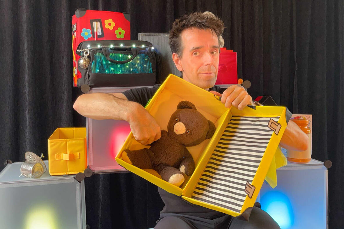 Zouick, fouick, Touick Monsieur Fred sur scène dans son décor imaginaire, présentant “Zouick, fouick, touick” à un jeune public émerveillé.