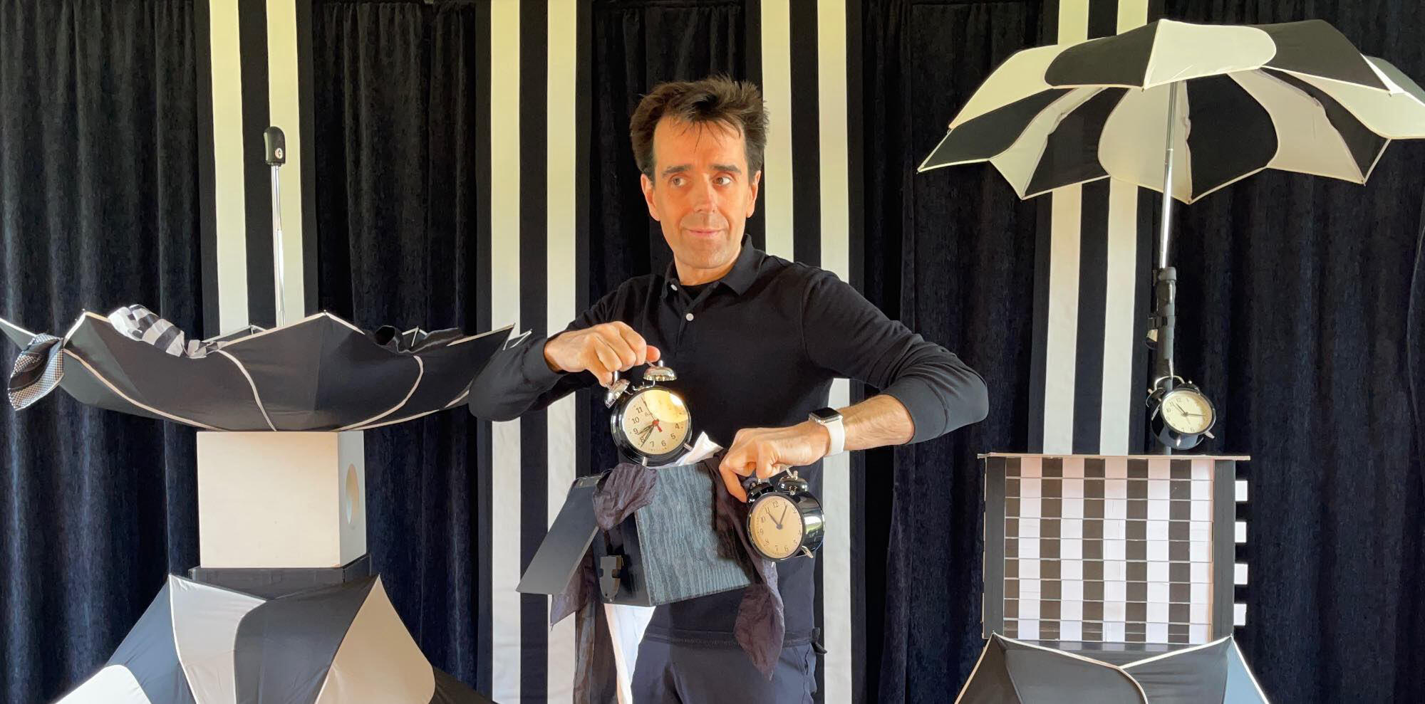 Monsieur Fred sur scène, captivant le public avec ses tours de magie et illusions d’optique, dans un décor original et surprenant.